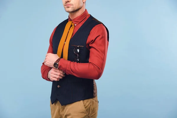 Corte vista de homem elegante em desgaste formal ajustando camisa isolada em azul — Fotografia de Stock