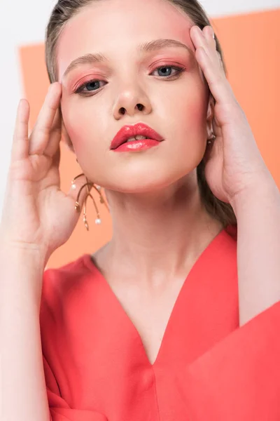 Selective focus of beautiful fashionable girl touching face and posing with living coral on background — Stock Photo