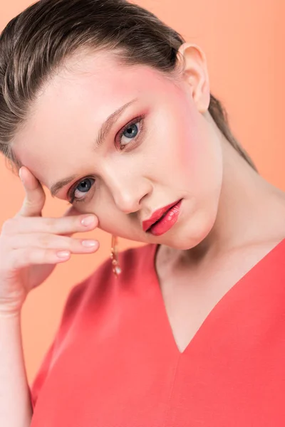 Portrait of beautiful fashionable girl looking at camera and posing isolated on living coral — Stock Photo