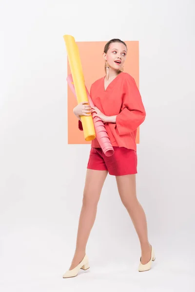 Bela menina elegante segurando rolos de papel e posando com coral vivo no fundo — Fotografia de Stock