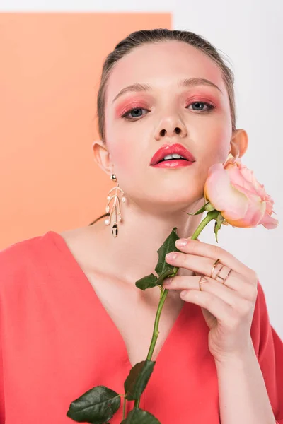 Beautiful stylish girl looking at camera, holding rose and posing with living coral on background — Stock Photo