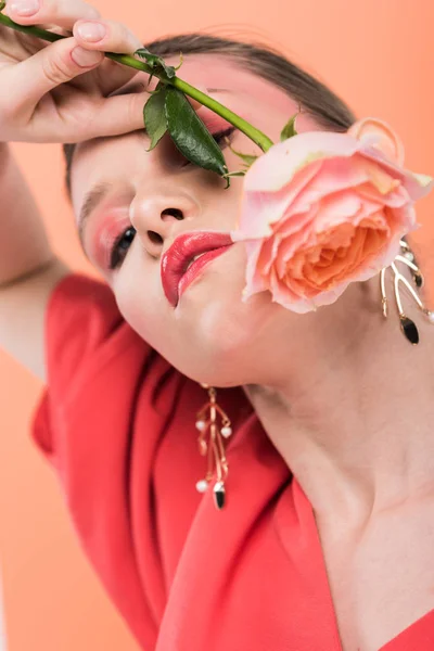 Portrait of beautiful stylish girl holding rose and posing isolated on living coral — Stock Photo