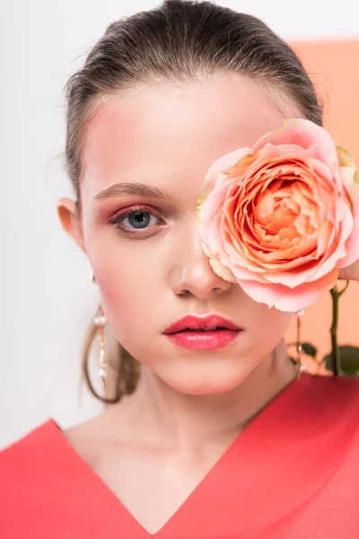 Bela menina elegante segurando rosa, olhando para a câmera e posando com coral vivo no fundo — Fotografia de Stock