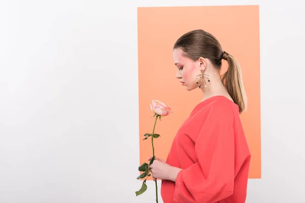 Belle fille à la mode tenant rose et posant avec corail vivant sur fond — Photo de stock