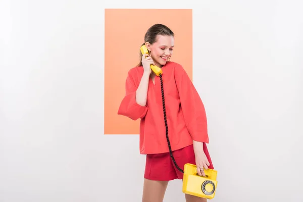 Menina elegante segurando telefone retro e posando com coral vivo no fundo — Fotografia de Stock