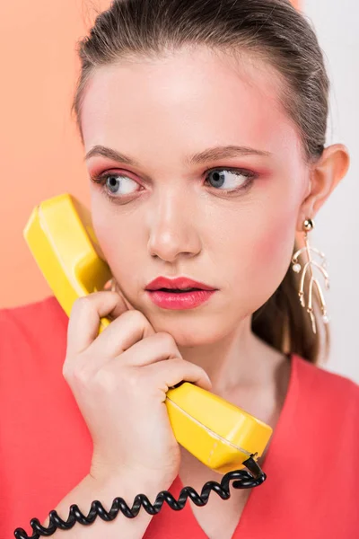 Bella ragazza alla moda parlando su telefono retrò con corallo vivente su sfondo — Foto stock