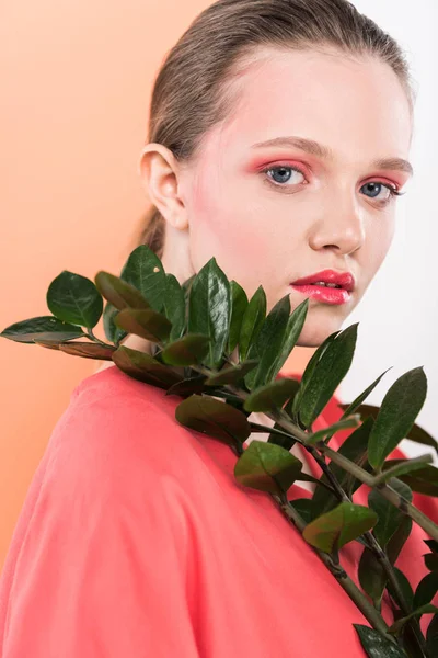 Beautiful stylish girl with plant looking at camera and posing with living coral on background — Stock Photo