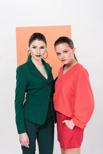 Beautiful trendy young women looking at camera and posing with living coral on background — Stock Photo