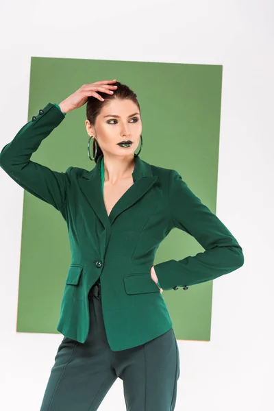 Красива модна жінка в офіційному одязі позує з морським зеленим на фоні — стокове фото
