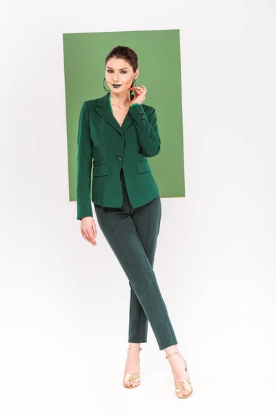 Красива модна жінка в формальному одязі дивиться в сторону і позує з морським зеленим на фоні — стокове фото