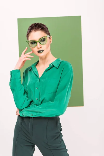 Beautiful fashionable woman in sunglasses posing with sea green on background — Stock Photo