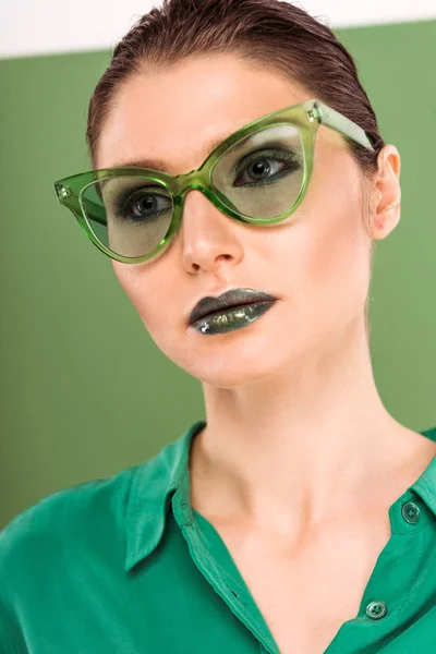 Portrait de belle femme à la mode dans des lunettes de soleil posant avec du vert de mer sur le fond — Photo de stock