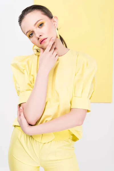 Beautiful stylish girl posig and looking at camera with limelight on background — Stock Photo