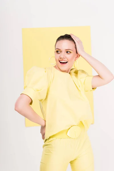 Belle fille élégante avec la main sur la tête souriante et posig avec la lumière sur le fond — Photo de stock