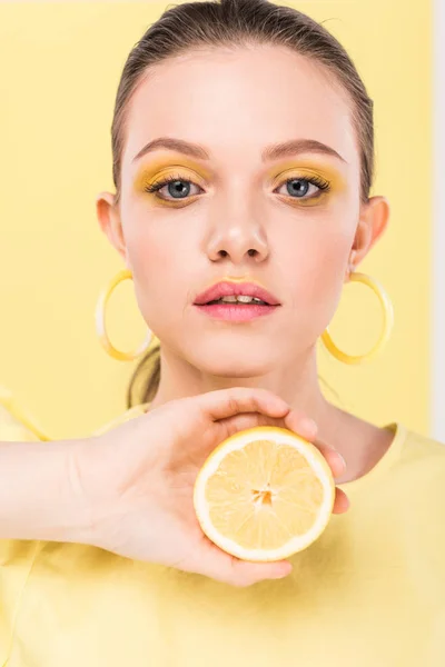 Bela menina elegante segurando limão, olhando para a câmera e posando isolado em ribalta — Fotografia de Stock