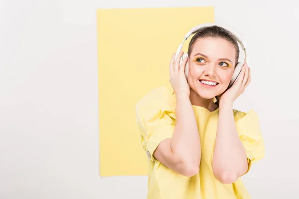 Sorrindo menina elegante em fones de ouvido ouvir música com espaço de cópia e ribalta no fundo — Fotografia de Stock