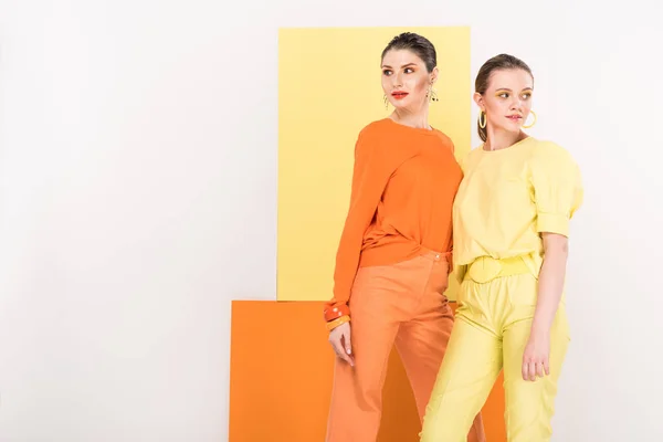 Beautiful fashionable girls posing with turmeric and limelight on background — Stock Photo