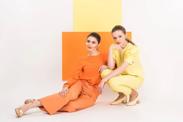 Beautiful stylish girls sitting and posing with turmeric and limelight on background — Stock Photo
