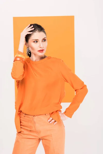 Beautiful fashionable woman with hand on head posing with turmeric on background — Stock Photo