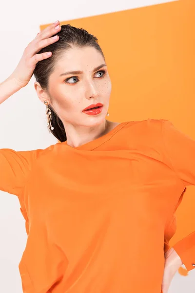 Beautiful fashionable woman with hand on head posing with turmeric on background — Stock Photo