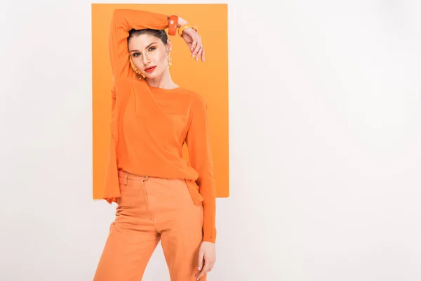 Beautiful fashionable woman looking at camera and posing with turmeric on background — Stock Photo