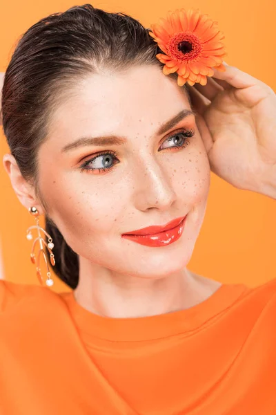 Portrait of beautiful young woman holding flower and posing isolated on turmeric — Stock Photo