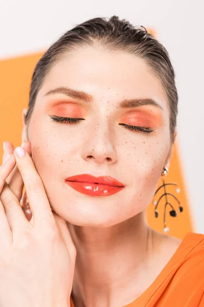 Beautiful fashionable young woman posing with eyes closed and tumeric on background — Stock Photo