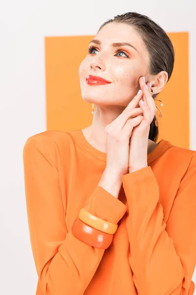 Enfoque selectivo de hermosa mujer joven de moda posando con tumérico en el fondo - foto de stock