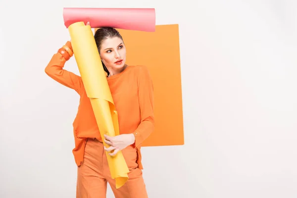 Mujer joven con estilo sosteniendo rollos de papel y posando con espacio de copia y cúrcuma en el fondo — Stock Photo