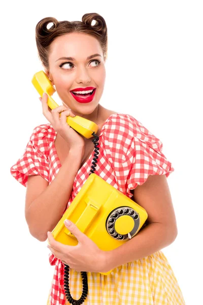 Улыбающаяся девушка разговаривает по старинному желтому телефону — стоковое фото