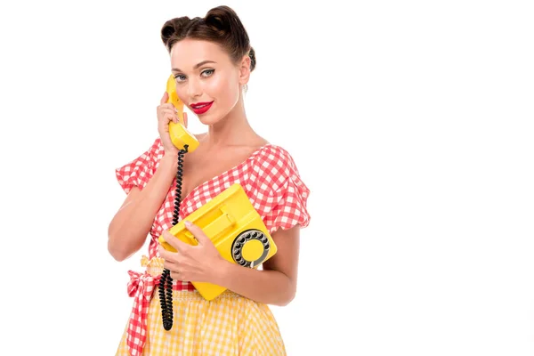 Schöne Pin-up-Mädchen spricht auf alten gelben Telefon und schaut in die Kamera — Stockfoto