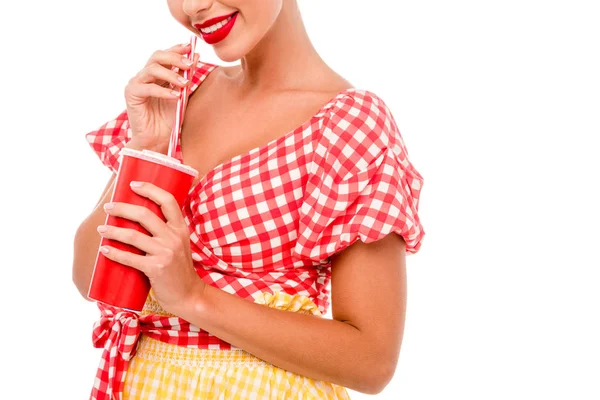 Vista parziale di pin up ragazza che beve da tazza di smaltimento rosso con paglia isolata su bianco — Foto stock