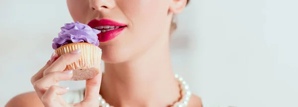 Частичный вид булавки девушки дегустации домашнего кекса с фиолетовым кремом — стоковое фото