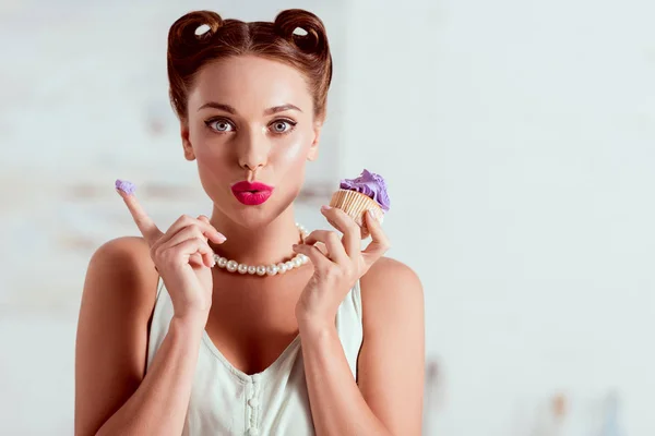 Schöne Pin-up-Mädchen hält hausgemachten Cupcake — Stockfoto