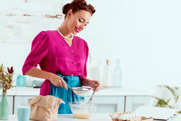 Smiling elegant pin up girl mixing ingredients for dough — Stock Photo