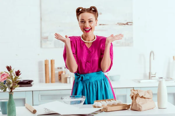 Sorridente pin up ragazza in piedi vicino tavolo da cucina con vari ingredienti — Foto stock