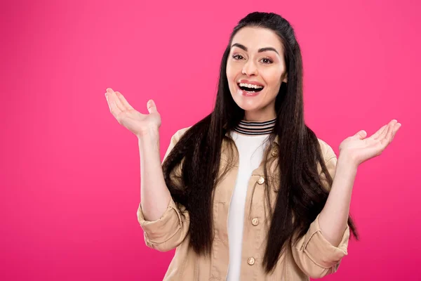 Fröhliche junge Frau gestikuliert mit den Händen und lächelt in die Kamera isoliert auf rosa — Stockfoto