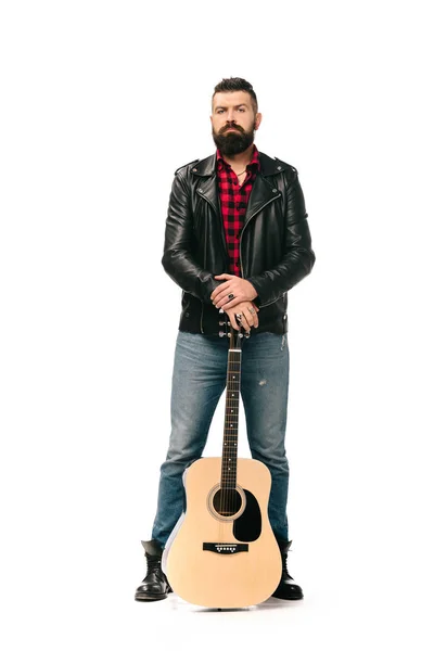 Handsome rocker in black leather jacket posing with acoustic guitar, isolated on white — Stock Photo