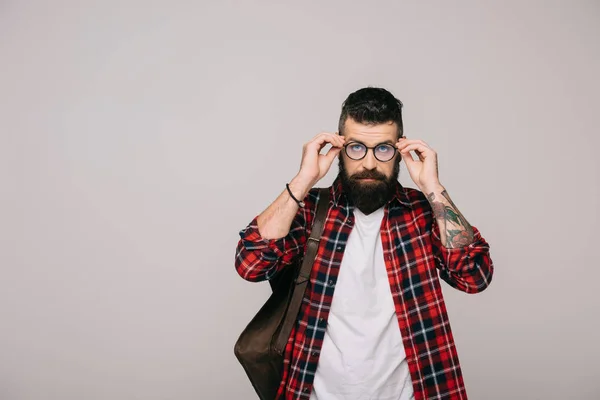 Schöner bärtiger Mann mit Brille und Rucksack, isoliert auf grau — Stockfoto