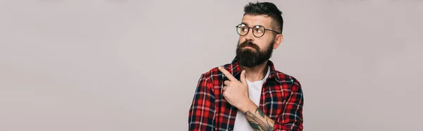 Beautiful stylish bearded man pointing isolated on grey — стоковое фото