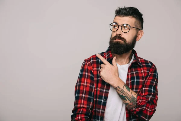 Стильний бородатий чоловік вказує ізольовано на сірий — стокове фото