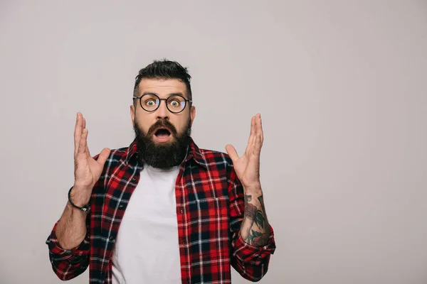 Uomo barbuto scioccato in camicia a scacchi gesticolando isolato su grigio — Foto stock