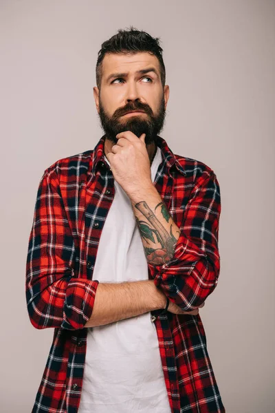 Hombre barbudo pensativo con camisa a cuadros aislado en gris - foto de stock
