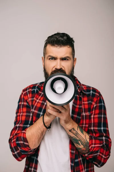 Angry bearded man yelling into megaphone, isolated on grey — Stock Photo