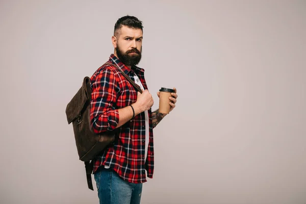 Homme beau sérieux en chemise à carreaux tenant tasse de café en papier isolé sur gris — Photo de stock