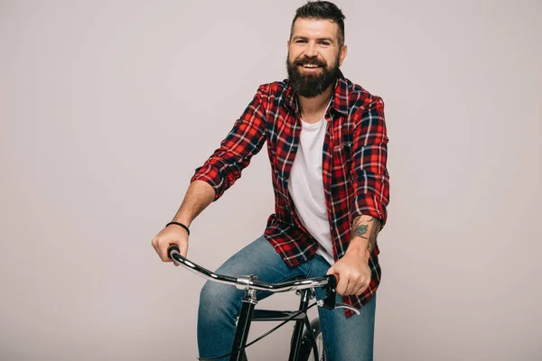 Bell'uomo sorridente in bicicletta isolato sul grigio — Foto stock