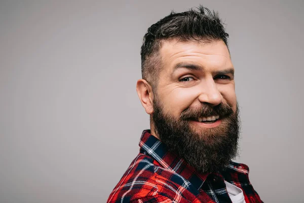 Hombre barbudo feliz con camisa a cuadros aislada en gris - foto de stock