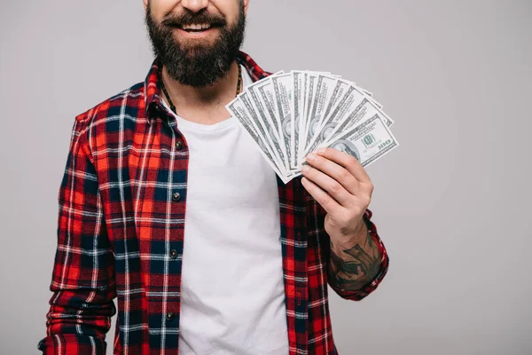 Vista cortada de homem barbudo segurando notas de dólar isoladas em cinza — Fotografia de Stock