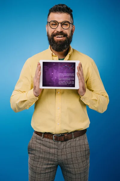 Smiling bearded man showing digital tablet with infographic app, isolated on blue — Stock Photo