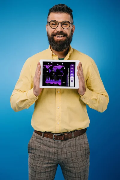 Lächelnder bärtiger Mann präsentiert digitales Tablet mit Infografik, isoliert auf blauem Grund — Stockfoto